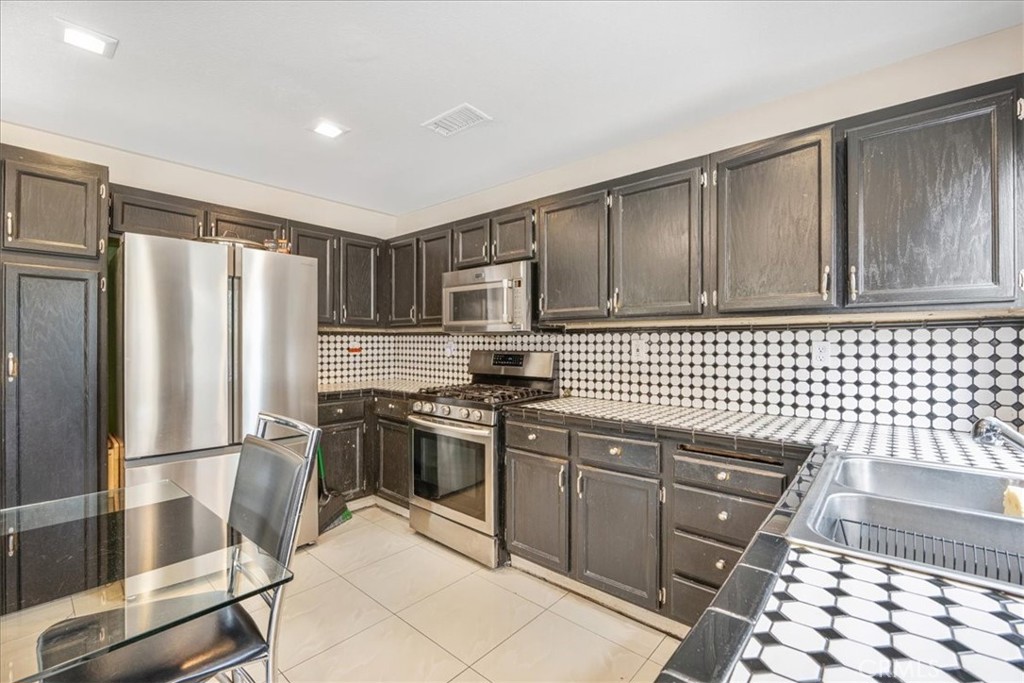 507 Coudures Way Perris, CA 92571 - Photo 15 of 41 a kitchen with granite countertop a refrigerator stove and sink