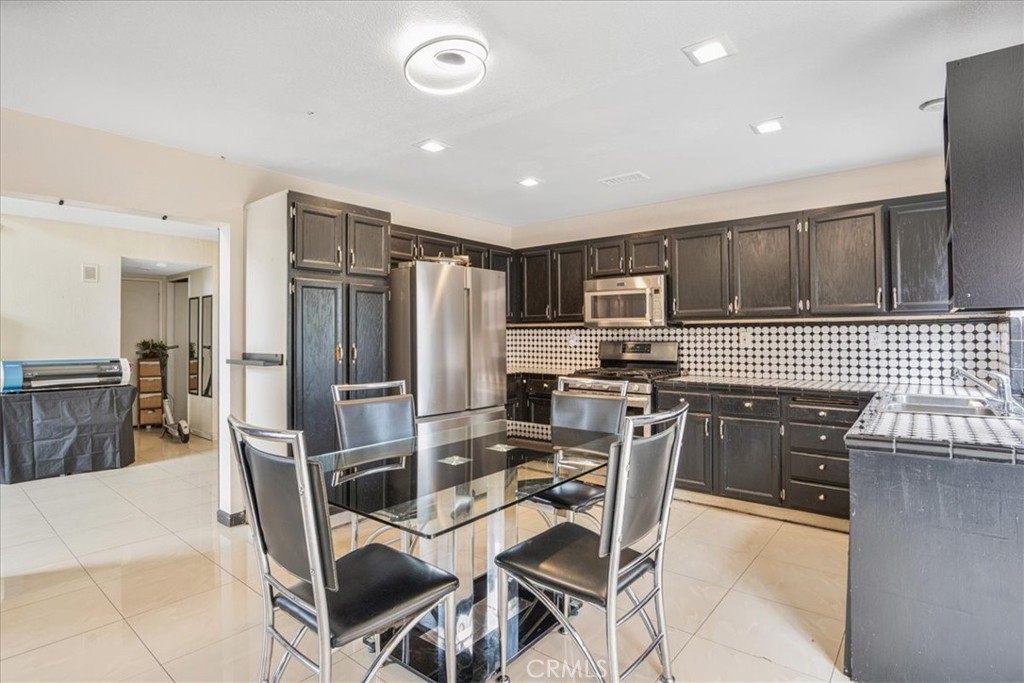 507 Coudures Way Perris, CA 92571 - Photo 16 of 41 a kitchen with stainless steel appliances granite countertop a refrigerator and a stove top oven