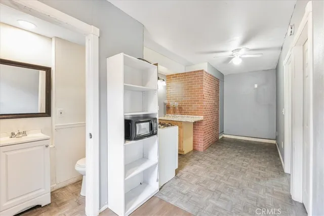 a view of a hallway with bathroom and wooden floor