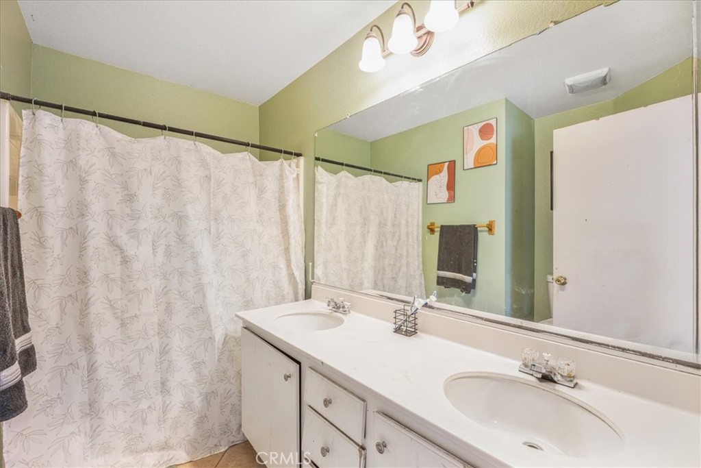 507 Coudures Way Perris, CA 92571 - Photo 27 of 41 a bathroom with a double vanity sink and a mirror
