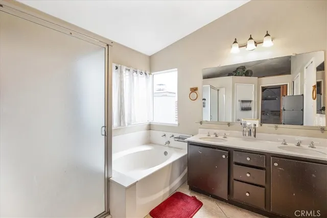 a spacious bathroom with a double vanity sink mirror and a bathtub
