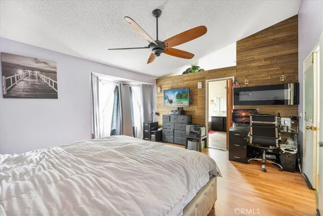 a bedroom with a bed and a flat tv screen on dresser