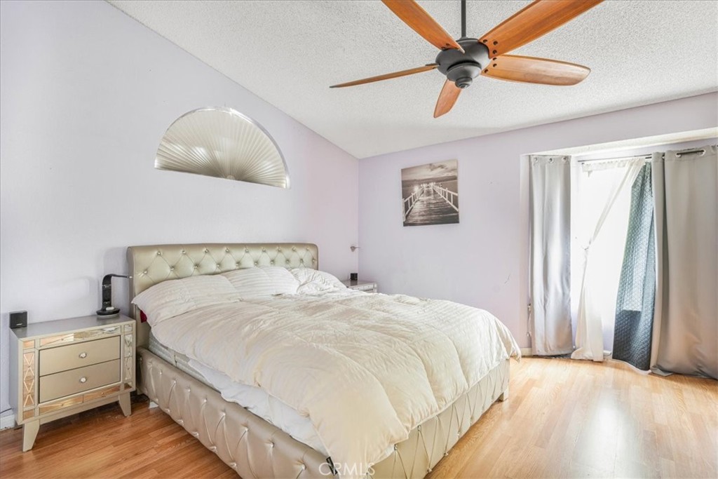 507 Coudures Way Perris, CA 92571 - Photo 33 of 41 a spacious bedroom with a bed and a chandelier