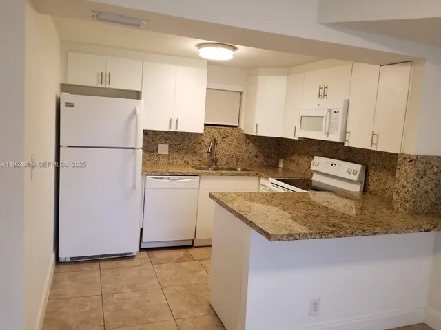 a kitchen with a sink refrigerator and cabinets