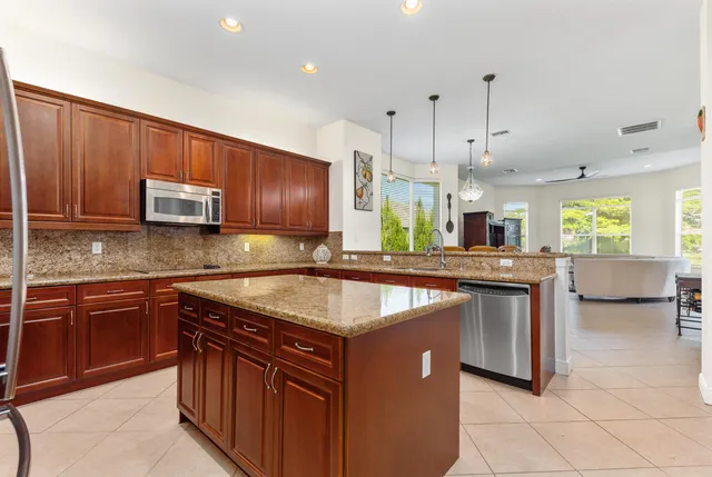 a kitchen with stainless steel appliances granite countertop wooden cabinets a sink and a stove