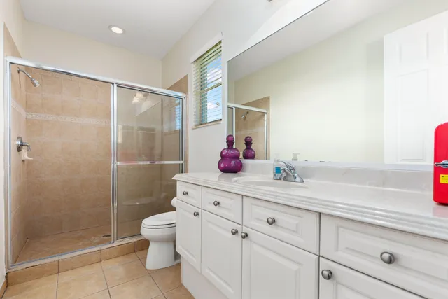 a bathroom with a shower sink vanity mirror and toilet