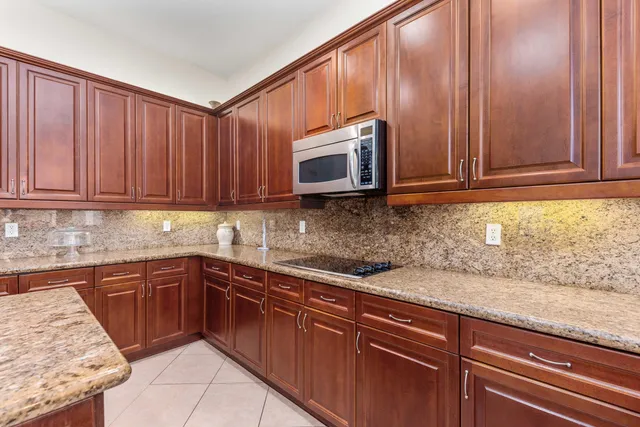 a kitchen with granite countertop wooden cabinets stainless steel appliances and a sink