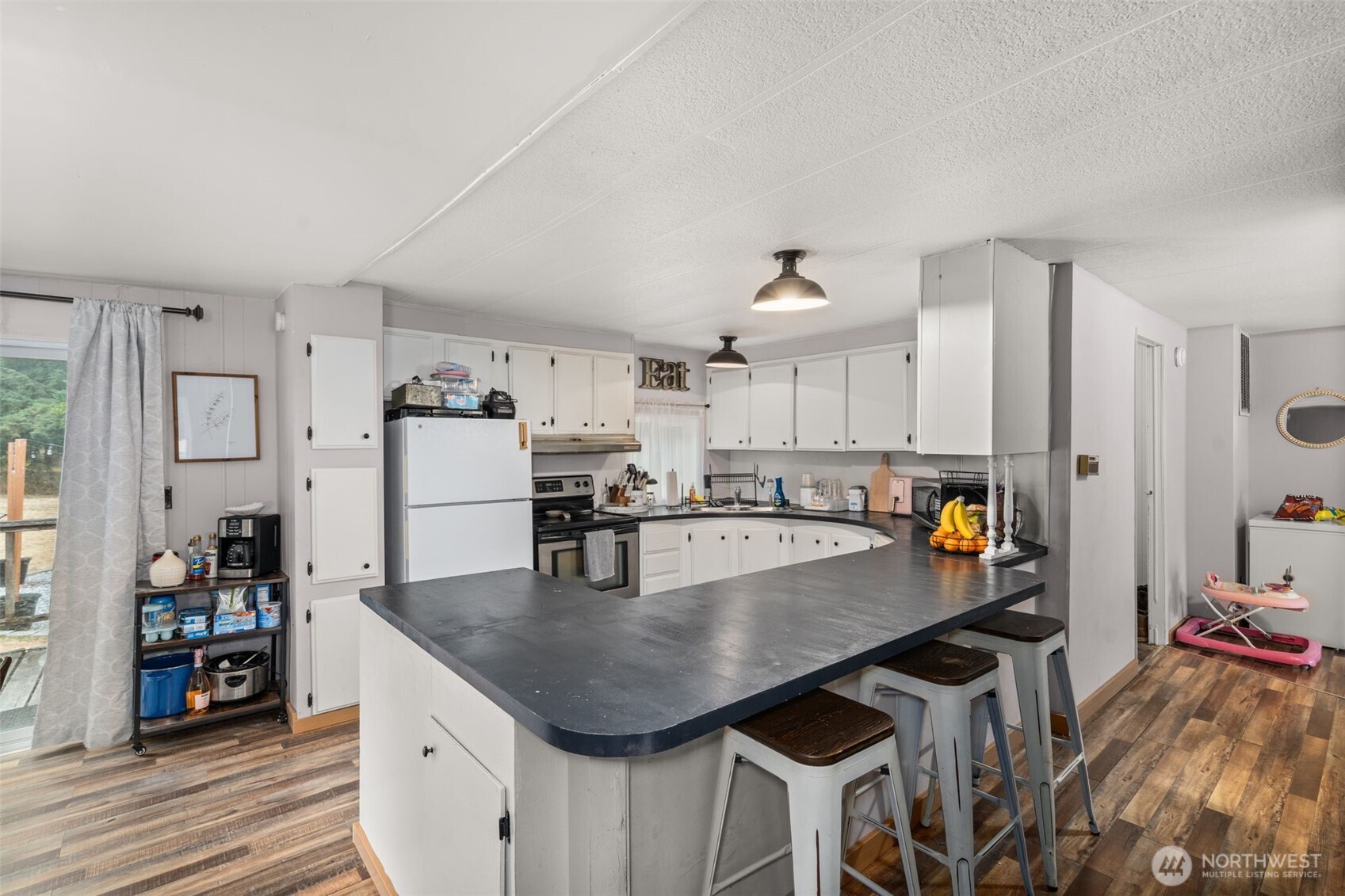 19121 Elderberry Street Southwest Rochester, WA 98579 - Photo 12 of 34 a kitchen with stainless steel appliances a table chairs and a refrigerator