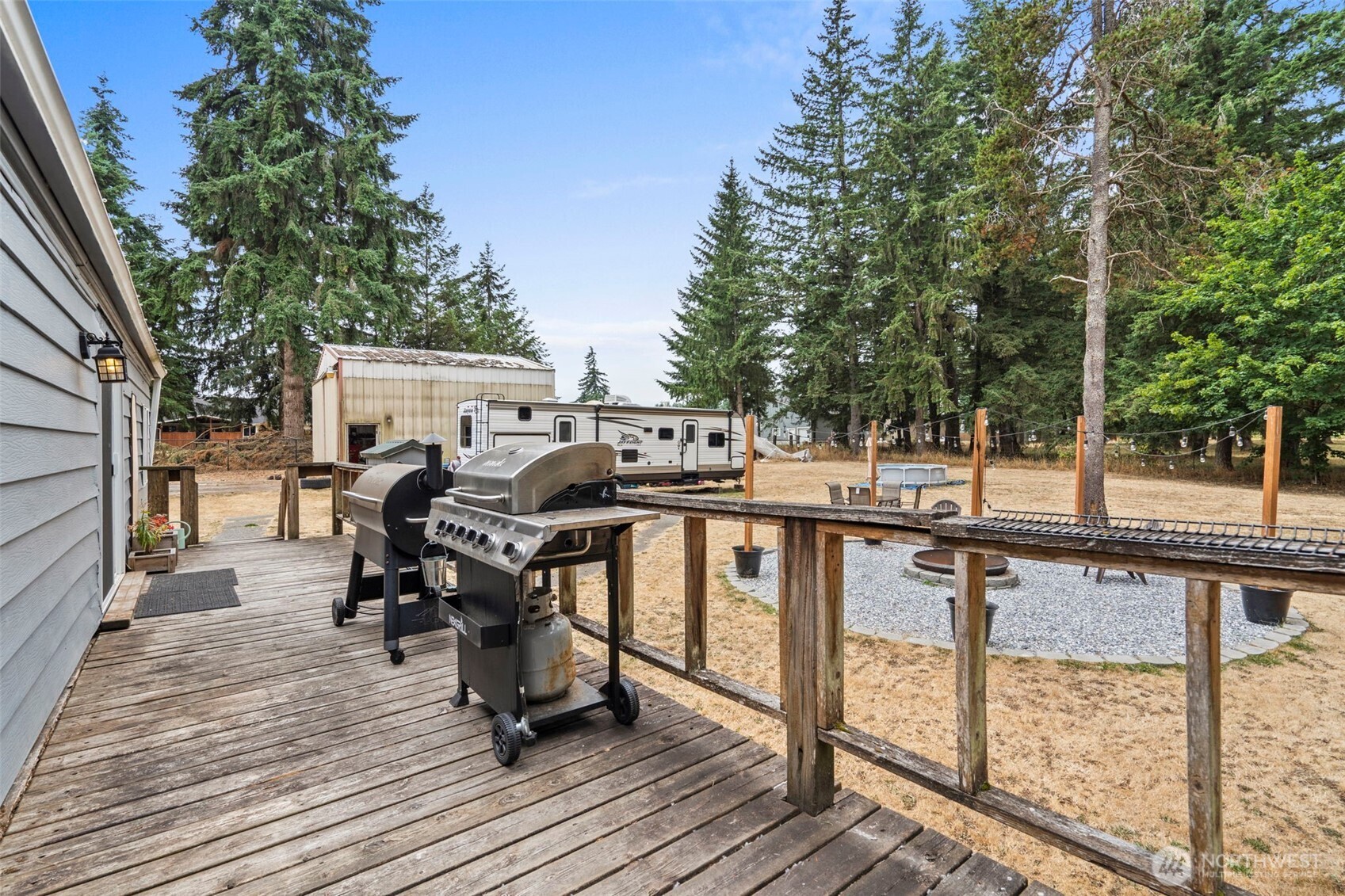 19121 Elderberry Street Southwest Rochester, WA 98579 - Photo 30 of 34 a view of a deck with chairs a barbeque with wooden floor and fence