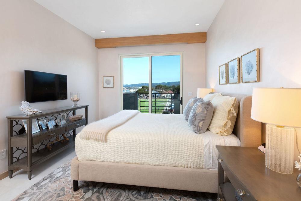 201 Cannery Row, Unit 6 Monterey, CA 93940 - Photo 21 of 30 a bedroom with a large bed and a flat screen tv