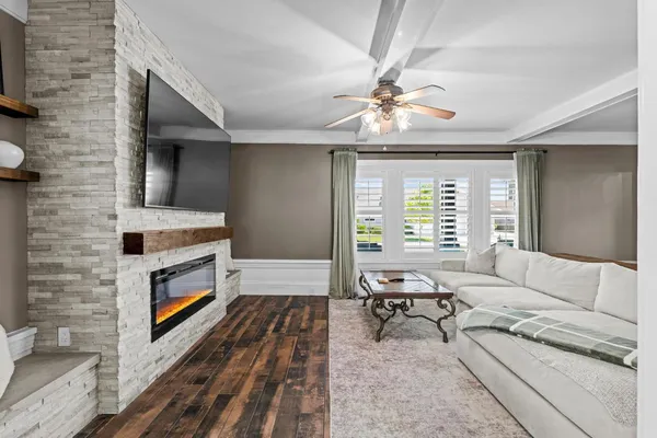 a view of a dining room and livingroom with furniture wooden floor a chandelier