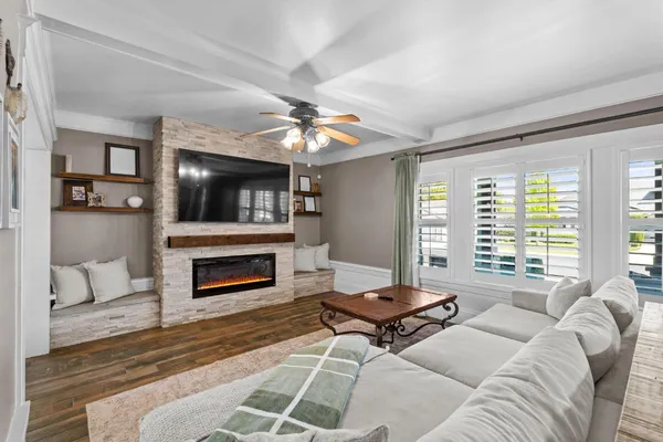 a living room with furniture a fireplace and a flat screen tv