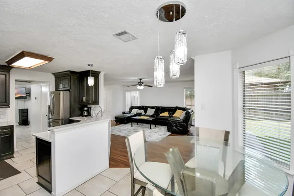 a kitchen with granite countertop a refrigerator stove sink and cabinets
