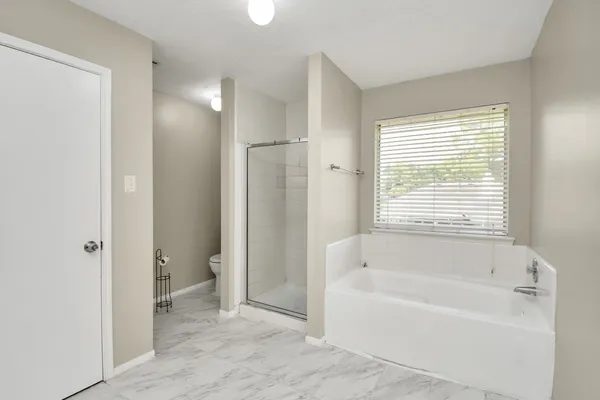 a bathroom with a tub a sink and a large mirror