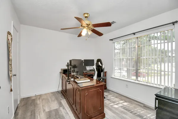 a view of a room that has a window and a ceiling fan