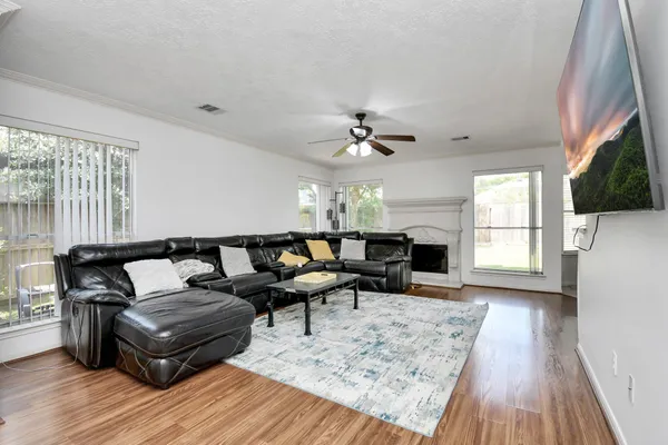a living room with furniture a flat screen tv and kitchen view