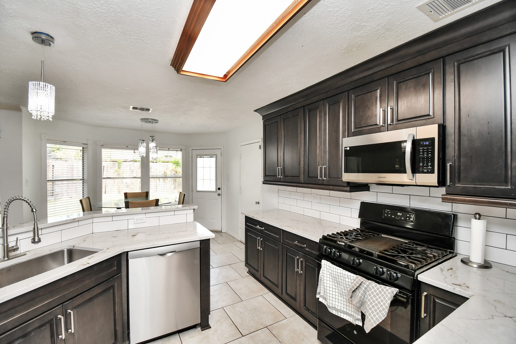 3402 Haydee Road Spring, TX 77388 - Photo 9 of 26 a kitchen with stainless steel appliances a stove sink microwave and cabinets