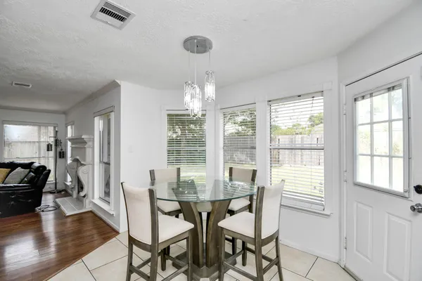 a kitchen with a sink a stove a refrigerator a dining table and chairs