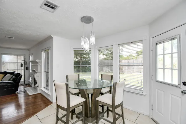 a kitchen with a sink a stove a refrigerator a dining table and chairs