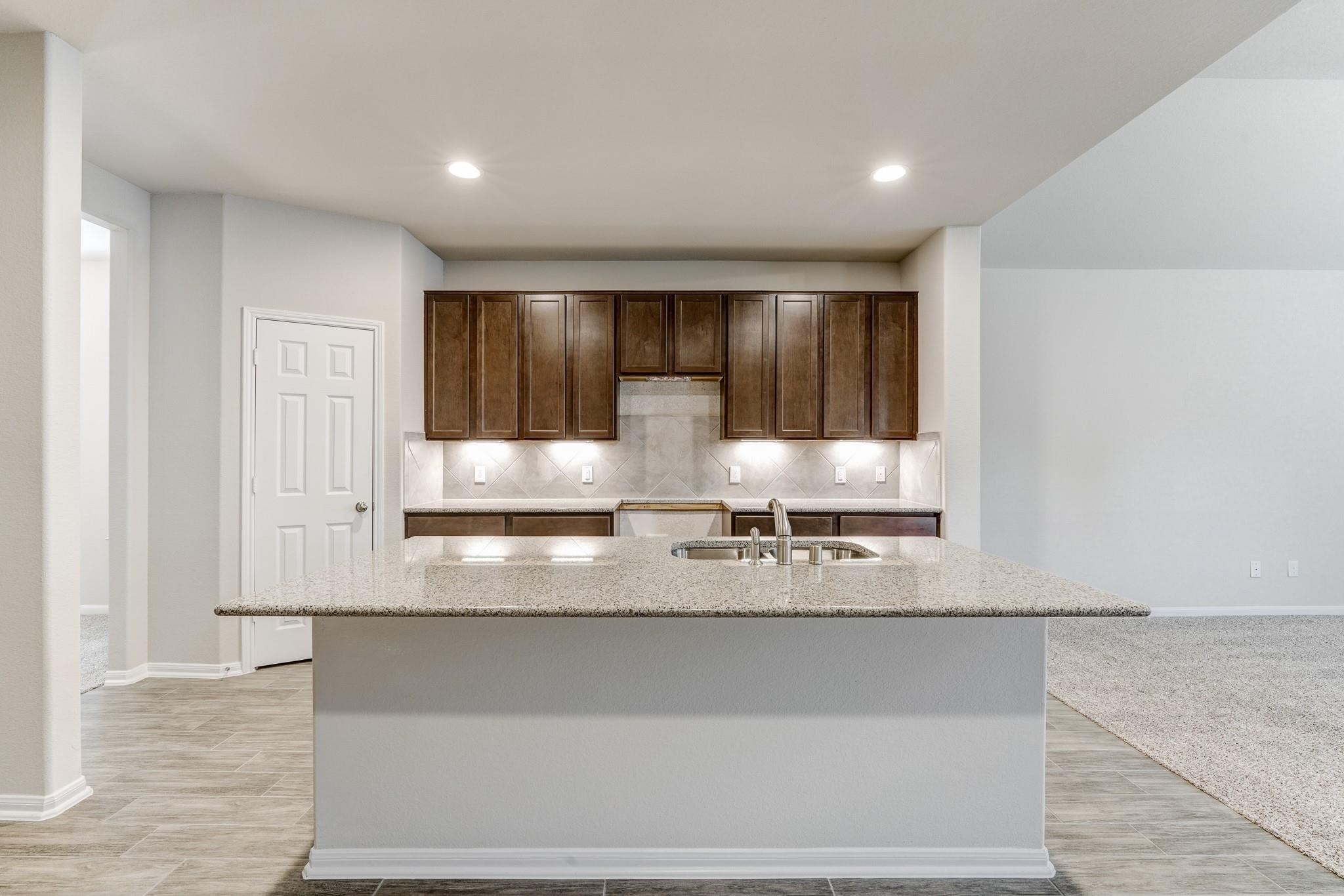 951 Willowick Road Houston, TX 77090 - Photo 2 of 9 a view of a kitchen with granite countertop cabinets and a sink