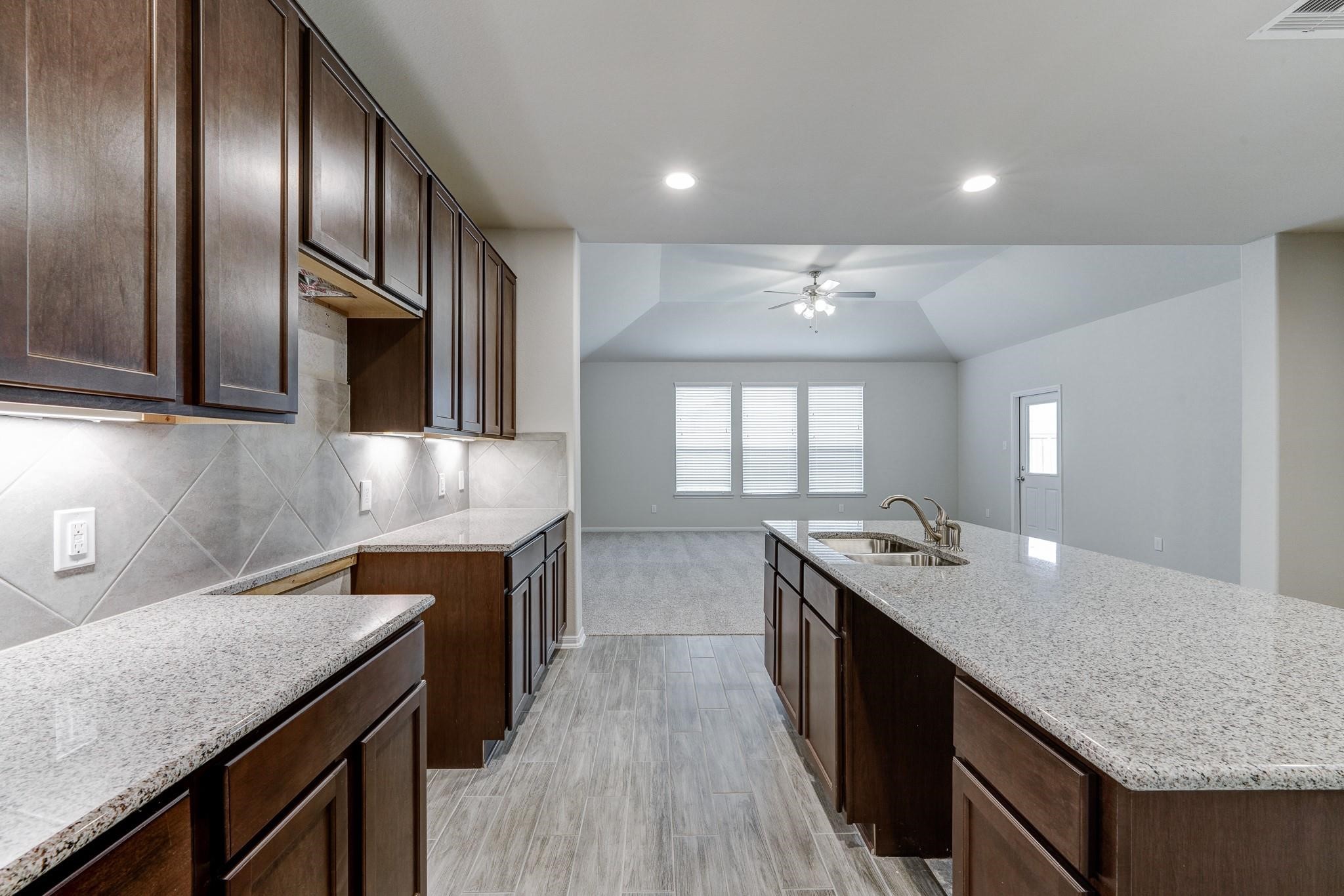 951 Willowick Road Houston, TX 77090 - Photo 3 of 9 a kitchen with granite countertop stainless steel appliances and wooden cabinets