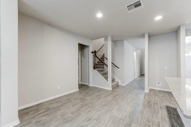 an empty room with wooden floor and entryway