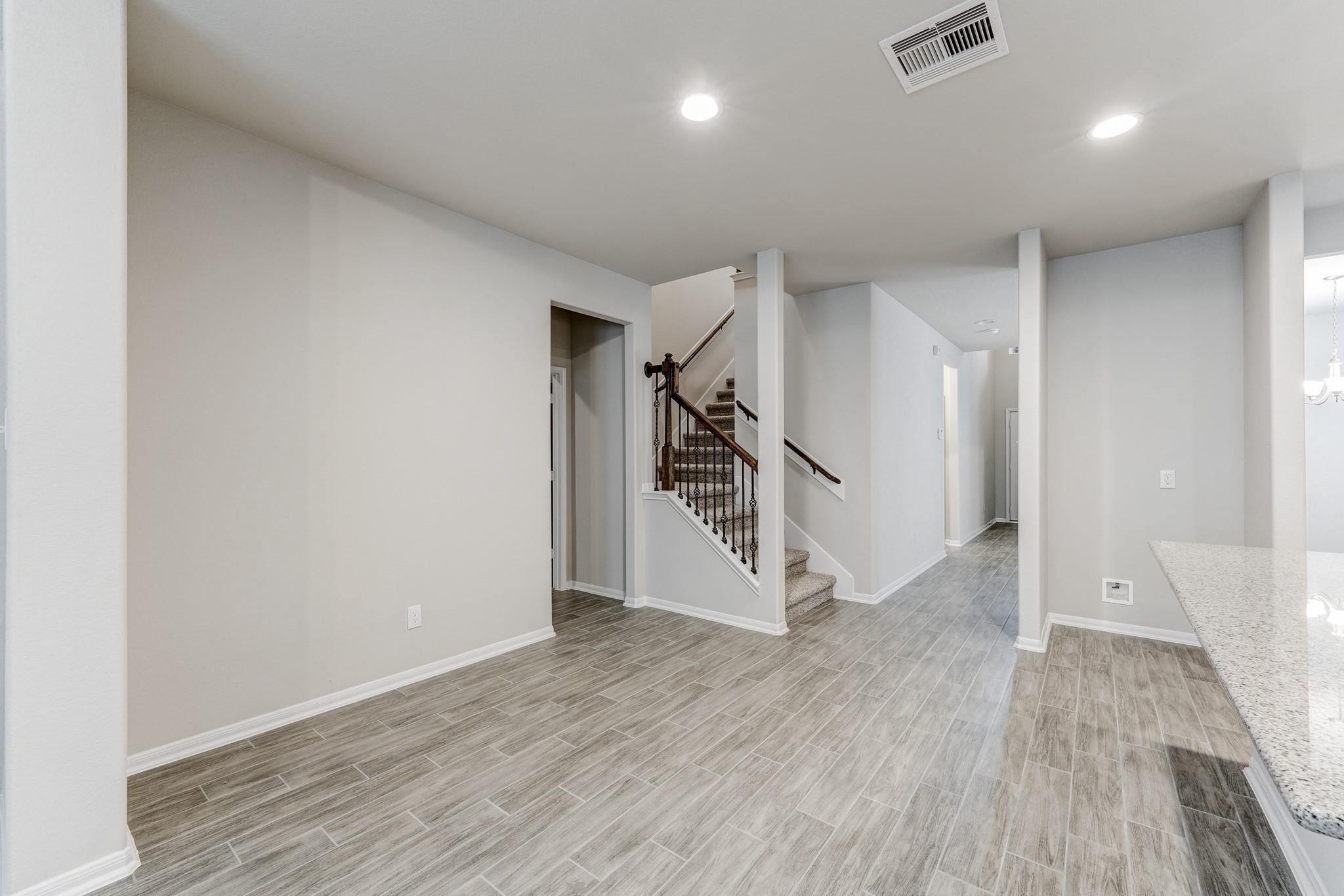 951 Willowick Road Houston, TX 77090 - Photo 4 of 9 an empty room with wooden floor and entryway