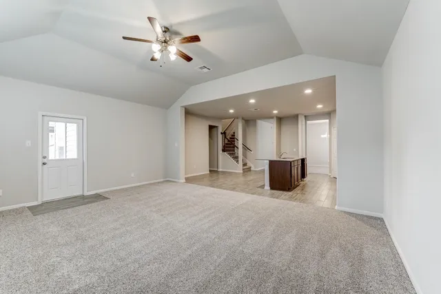 a view of a livingroom with a kitchen and a ceiling fan