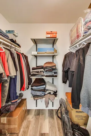 a view of walk in closet with clothes and shoes