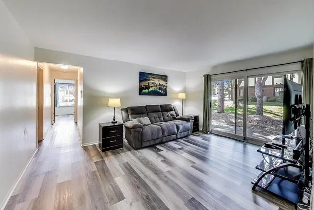 a living room with furniture a flat screen tv and a floor to ceiling window
