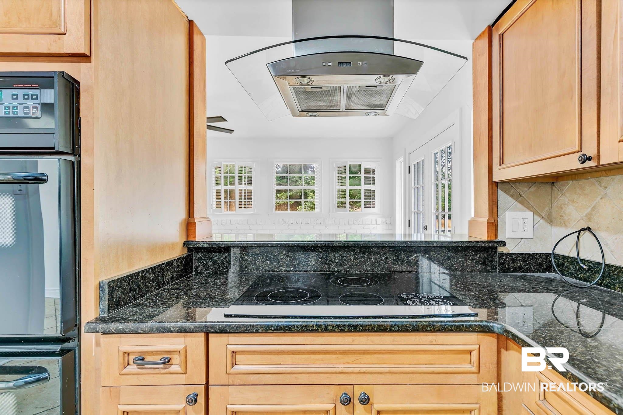 4705 Sherry Court Mobile, AL 36693 - Photo 21 of 100 Kitchen with extractor fan, black appliances, dark stone counters, and light brown cabinets