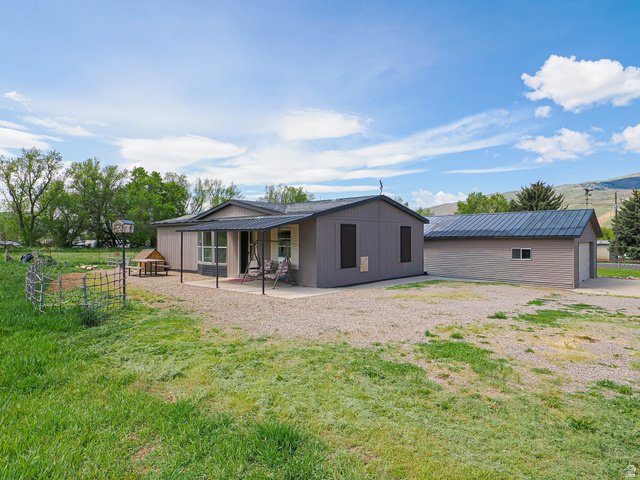 94 Spring Canyon Road Coalville, UT 84017 - Photo 6 of 50 Single-story residence featuring a covered front porch and a detached garage with a metal roof