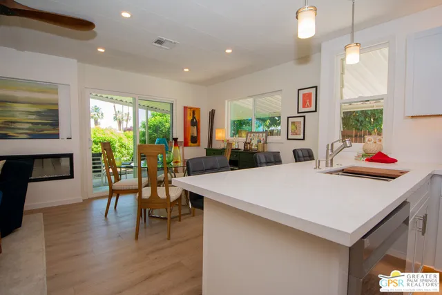 a large kitchen with sink a refrigerator and chairs