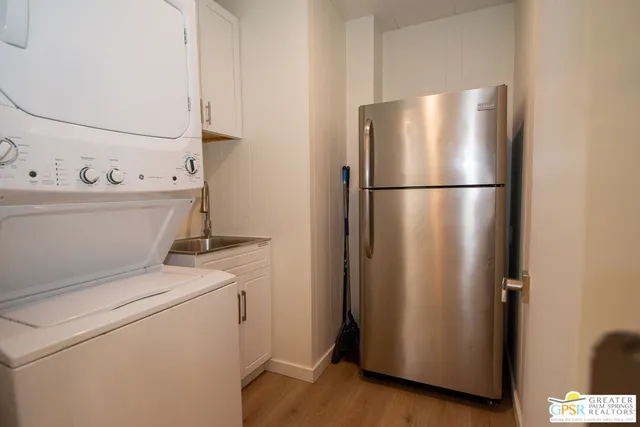 a view of kitchen with refrigerator and wooden floor