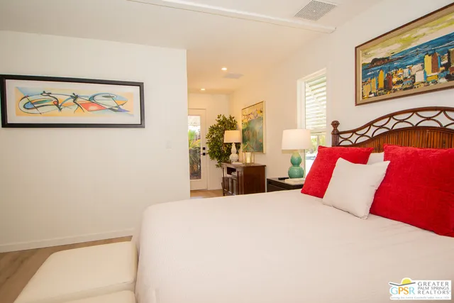 a bed room with a bed and a painting on the wall