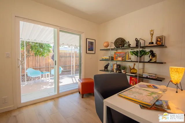 a view of a workspace with furniture and a window
