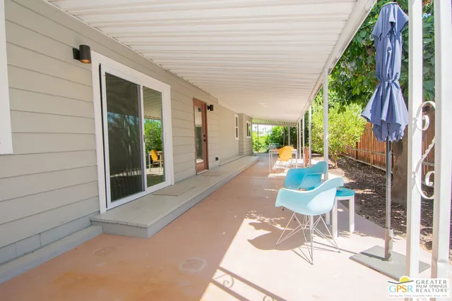 a view of a porch with wooden floor and iron stairs