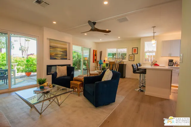 a living room with furniture fireplace and a large window
