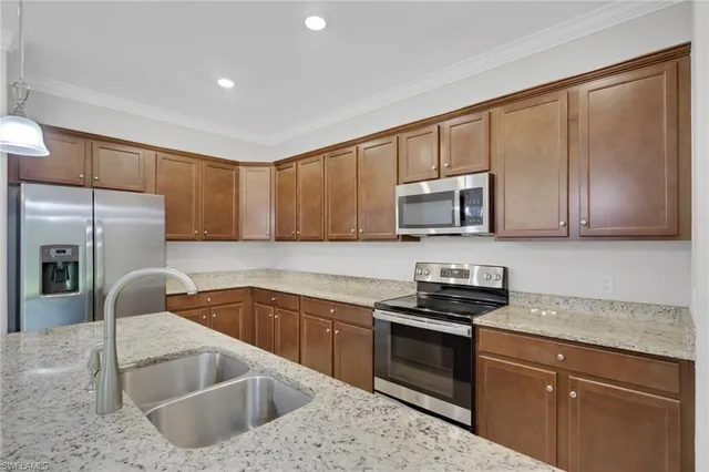 a kitchen with stainless steel appliances granite countertop a sink stove and microwave