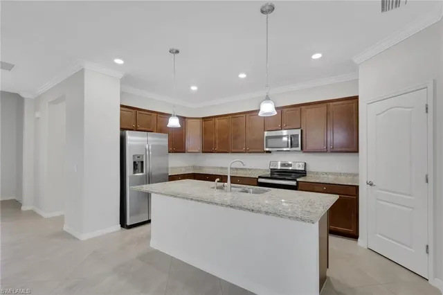 a kitchen with stainless steel appliances granite countertop a refrigerator a sink a stove and a refrigerator