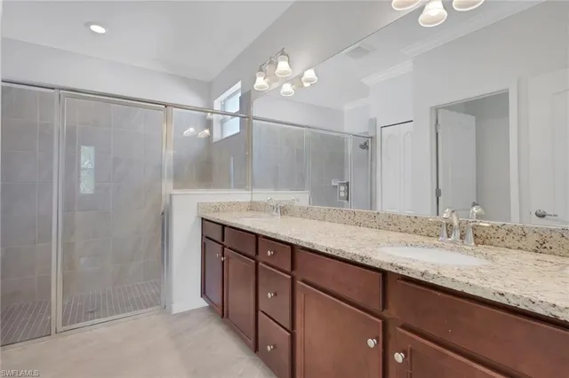 a bathroom with a granite countertop sink a mirror and a shower