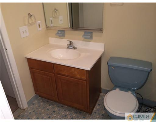 281 Rector Street Perth Amboy, NJ 08861 - Photo 8 of 10 a bathroom with a toilet a sink and mirror
