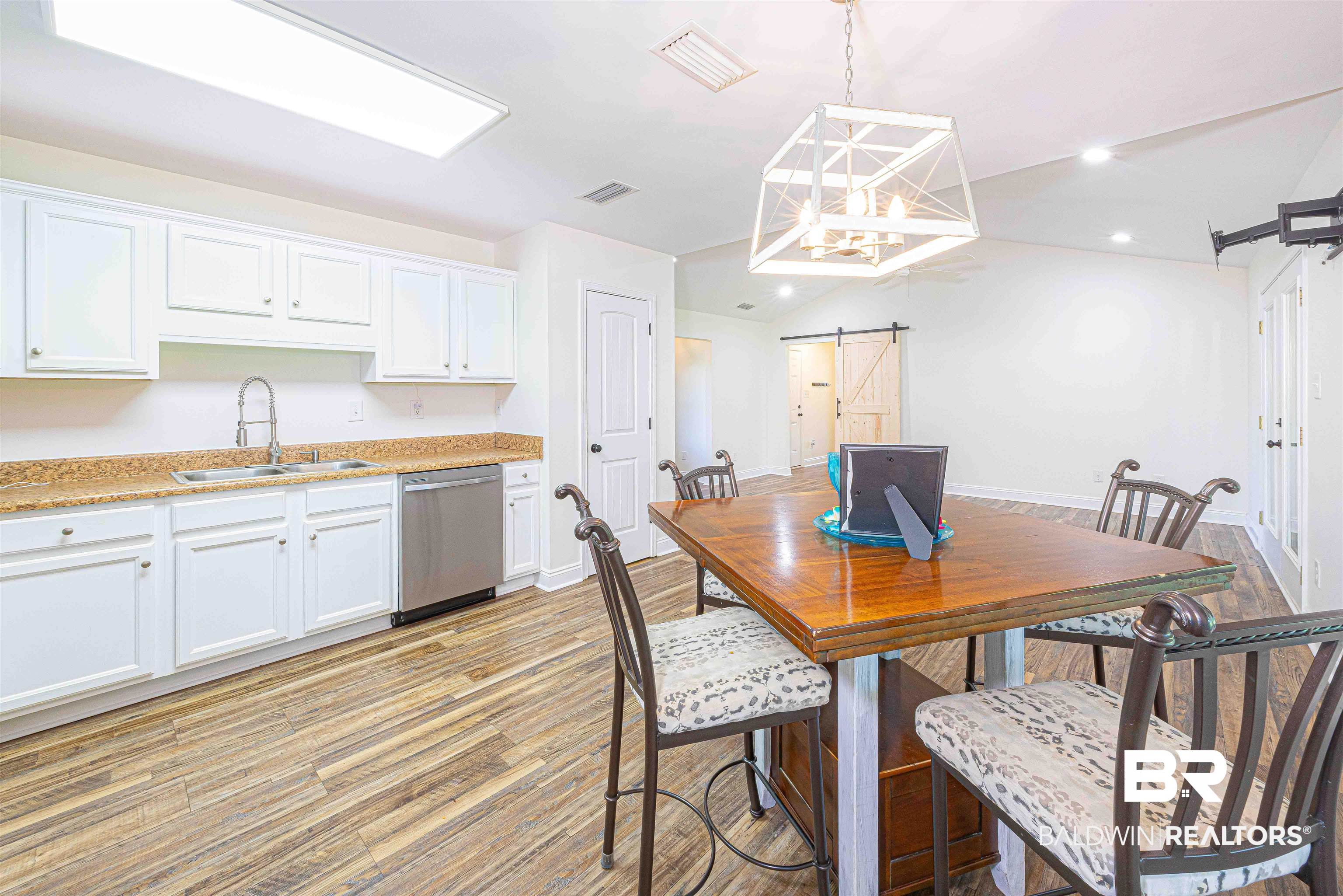 18675 Explorer Drive Loxley, AL 36551 - Photo 14 of 42 Dining area featuring a barn door, light wood-style flooring, recessed lighting, a chandelier, and lofted ceiling