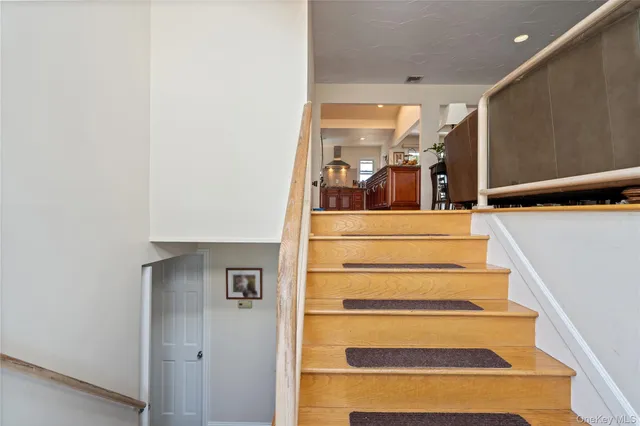 a view of staircase with white walls and a glass door