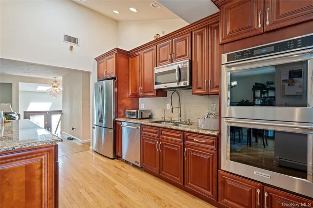 a kitchen with stainless steel appliances granite countertop a refrigerator stove and sink