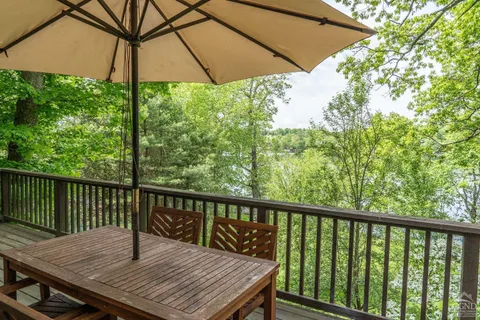 a view of balcony with wooden floor and umbrella