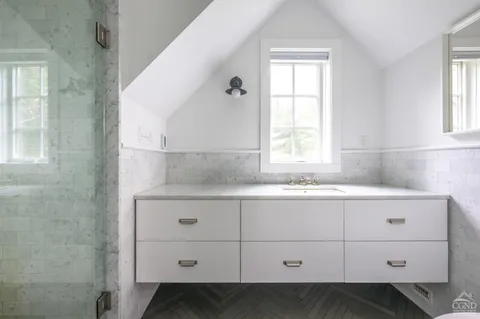 a bathroom with a sink mirror and a window