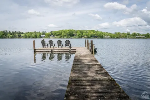 a view of a lake with a big yard and large trees