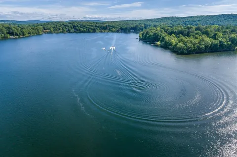 a view of a lake in middle of a field