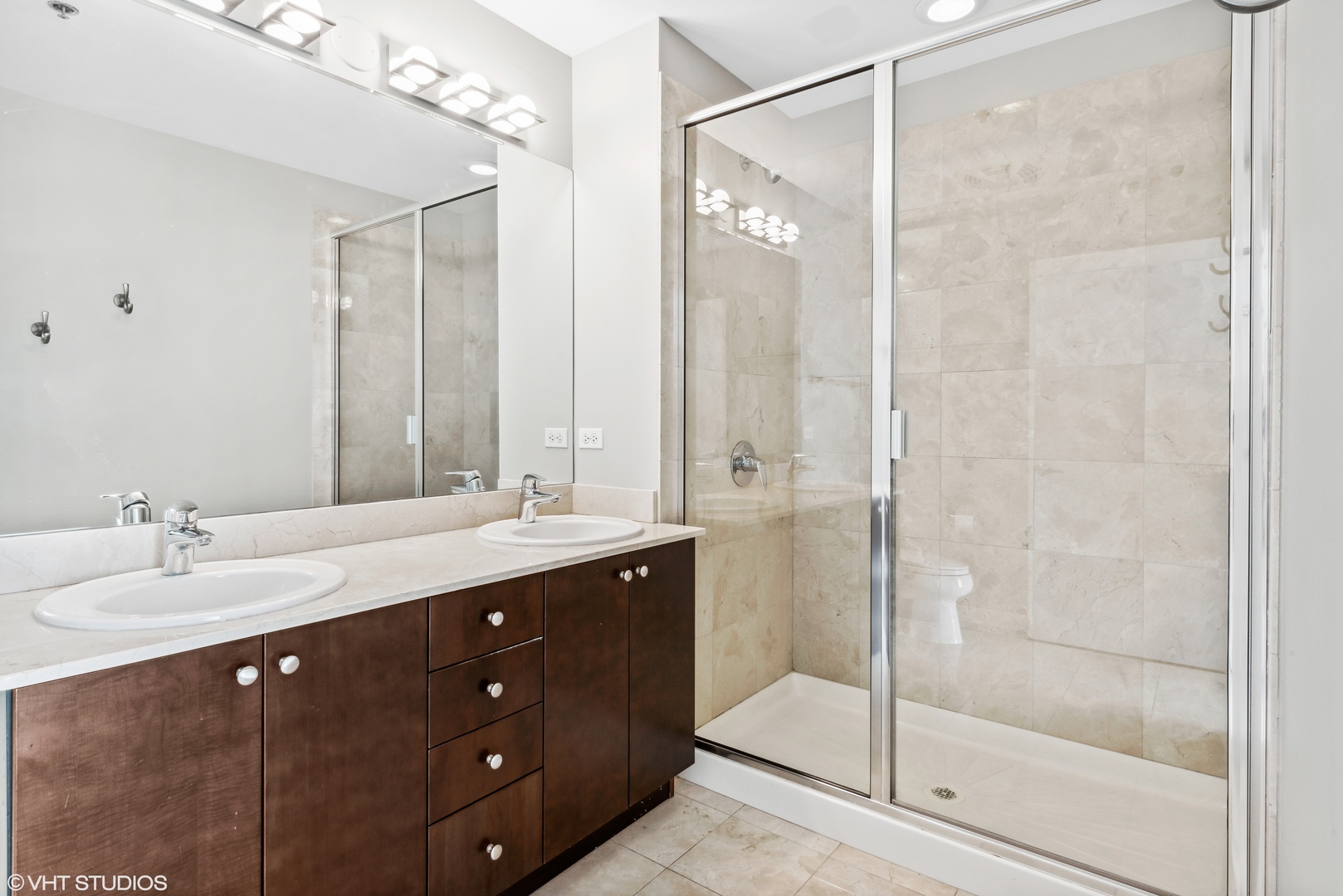 Undisclosed Address Chicago, IL 60654 - Photo 9 of 22 a bathroom with a double vanity sink mirror and shower